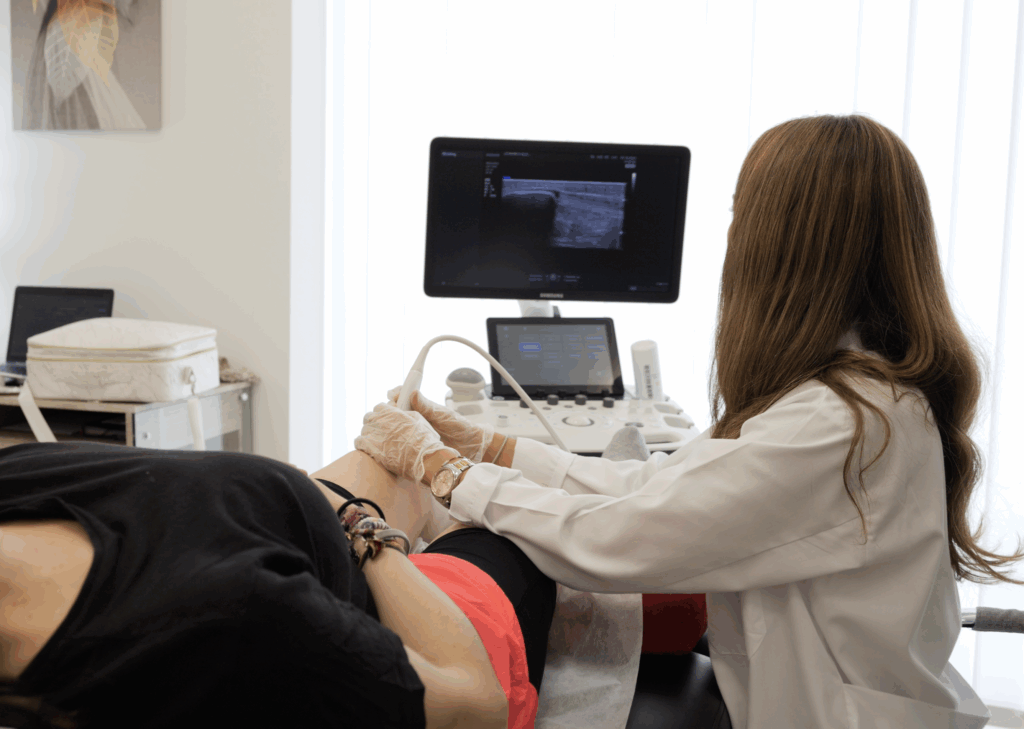 Profesional realizando una ecografía musculoesquelética en la pierna de un paciente para el diagnóstico preciso de una lesión.